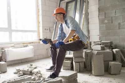 Boy holding a drill and surrounded by consruction